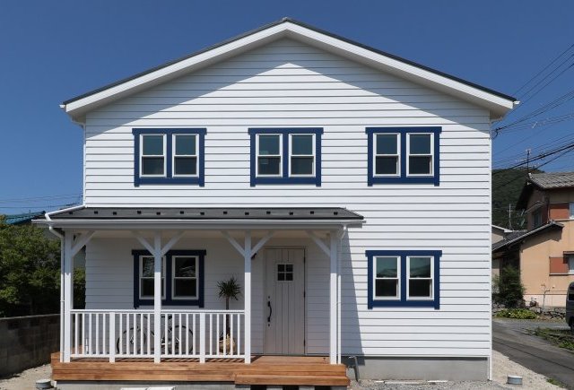 カバードポーチのあるネイビーがアクセントの家