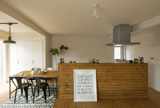 アイランドキッチンに木のアクセントウォールのある家